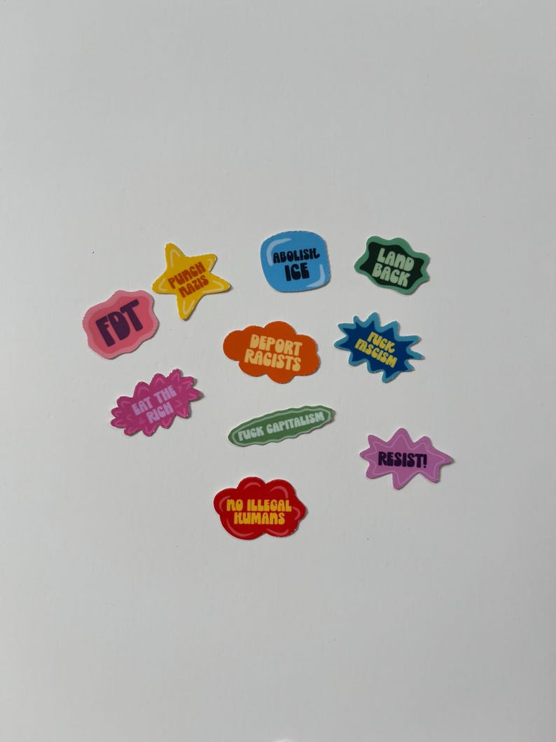 May include: A collection of colorful stickers with various phrases and slogans. The stickers are in different shapes, including stars, speech bubbles, and ovals. The text includes phrases like "Abolish ICE," "Resist!," and "Eat the Rich."