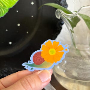Snailanthus Flower Snail Sticker – Cute Nature-Inspired Vinyl Sticker | Whimsical Garden Snail with Orange Bloom | cute snail sticker