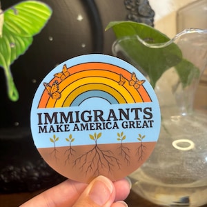 Pegatina &quot;Los inmigrantes hacen grande a Estados Unidos&quot; – Vinilo proinmigrante / Arte de justicia social, Diseño de mariposa con raíces arcoíris, Pegatina activista