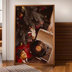 May include: A framed image featuring a Christmas tree, a record player with a vinyl record, and a red album cover with Frank Sinatra. The record player is open, with the needle on the record. The image is in a wooden frame.