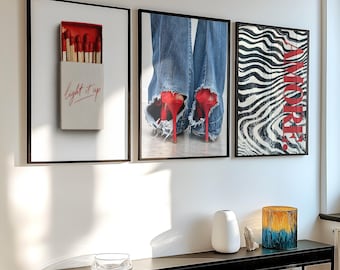 May include: Three framed wall art prints. The first shows a matchbox with red-tipped matches and the text light it up. The second displays blue denim jeans with frayed hems over red high heels. The third features black and white wavy lines with the red text AMORE.