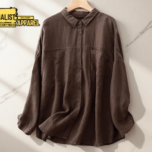 Könnte beinhalten: Ein braunes Button-Down-Hemd mit langen Ärmeln, zwei Brusttaschen und einem Kragen. Das Hemd hängt an einem Holzbügel. Der Text "MINIMALIST APPAREL" befindet sich in der oberen linken Ecke.