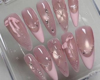 Ręcznie robione różowe, kokardkowe paznokcie do naprasowywania | Sztuczne paznokcie z 3D wstążką i pikowaną fakturą diamentów | Eleganckie, perłowe paznokcie typu french z kocim okiem