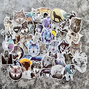 Könnte beinhalten: Eine Sammlung von Aufklebern zum Thema Wolf in verschiedenen Designs und Farben. Die Aufkleber zeigen detaillierte Illustrationen von Wölfen in verschiedenen Posen, darunter Heulen, Laufen und Stehen. Einige Aufkleber haben einen Aquarelleffekt, andere sind grafischer.