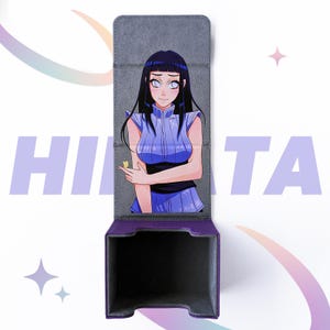 May include: A purple and gray card storage box featuring an anime character illustration. The box is open, revealing a black interior. The character is a woman with long black hair and a blue outfit. The word "HINATA" is printed in purple.