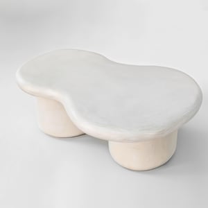 May include: White, organic-shaped coffee table with two rounded legs. The table is made of a smooth, white material.