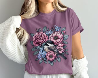 花の庭に佇む可愛い鳥のイラスト、美しい鳥のTシャツ、自然をテーマにしたTシャツ、花柄グラフィックTシャツ、夏のカジュアルウェア