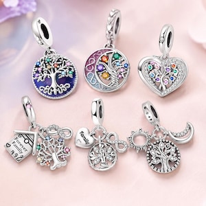 May include: Six silver charms featuring tree of life designs with colorful gemstones. One charm is a house shape with the text Forever Family, another is a heart shape, and others include infinity symbols, a sun, and a moon motif with clear crystals.