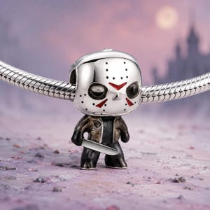 Puede incluir: Un abalorio plateado con forma de personaje que lleva una máscara de hockey y sostiene una pequeña hoja. La figura presenta una máscara blanca con detalles triangulares rojos, cuencas oculares negras y un atuendo oscuro en una cadena de serpiente.