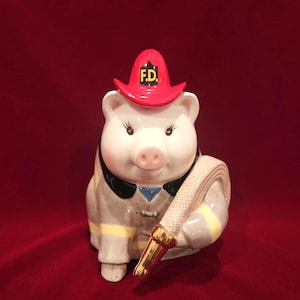 May include: A white ceramic mug with a black handle and the text "But First, Coffee" in a black, handwritten-style font. The mug is on a white surface.