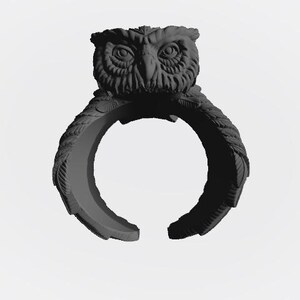 Op de afbeelding: Een donkergrijze uilenring. De ring heeft een gedetailleerde uilenkop aan de bovenkant, met getextureerde veren en grote ogen. De ringband is ook getextureerd, met een gespleten ontwerp. Een uniek sieraad.