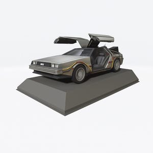 Puede incluir: Modelo plateado de DeLorean con puertas de ala de gaviota abiertas, exhibido sobre una plataforma gris. El coche presenta elementos exteriores detallados, incluyendo ruedas, molduras y asientos interiores. El modelo es una réplica del icónico coche de Regreso al Futuro.