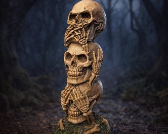 Könnte beinhalten: Eine gestapelte Skulptur aus drei Schädeln, wobei jede Hand den Mund, die Ohren und die Augen bedeckt. Die Schädel sind beige, mit sichtbaren Zähnen und Knochenstrukturen. Der Sockel ist mit grünem Moos bedeckt. Der Hintergrund ist ein dunkler Wald.