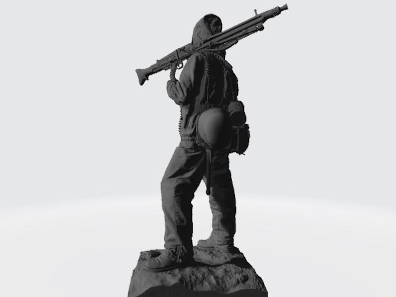 May include: A black and gray figurine of a soldier holding a machine gun. The soldier is wearing a hooded jacket and a helmet. The figurine is standing on a rocky base.