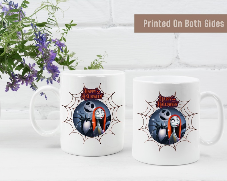 White ceramic mug featuring a colorful design with Jack Skellington and Sally inside a spiderweb frame, with pumpkins and Halloween text above.