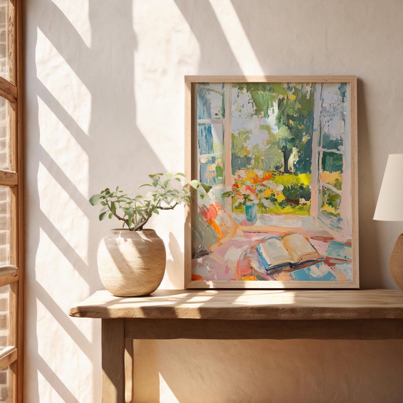 May include: A framed painting depicting a window with a view of a garden. The window is open and there are flowers in a vase on the windowsill. The painting is on a wooden table with a potted plant.