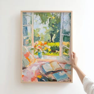 May include: A painting of a window with open French doors looking out onto a garden with a vase of flowers on a table with open books. The painting is in a light wood frame.