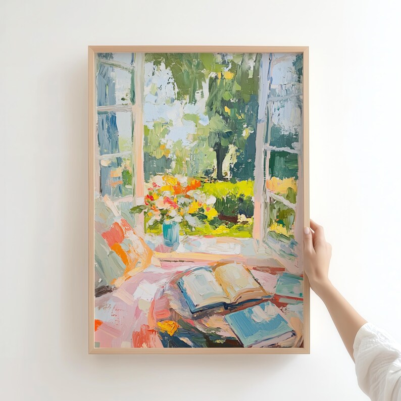 May include: A painting of a window with open French doors looking out onto a garden with a vase of flowers on a table with open books. The painting is in a light wood frame.
