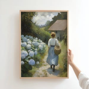 May include: A woman in a blue dress walks along a path lined with hydrangeas. She carries a wicker basket and is walking away from a small white house in the distance.