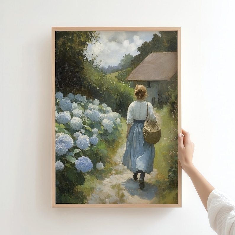 May include: A woman in a blue dress walks along a path lined with hydrangeas. She carries a wicker basket and is walking away from a small white house in the distance.