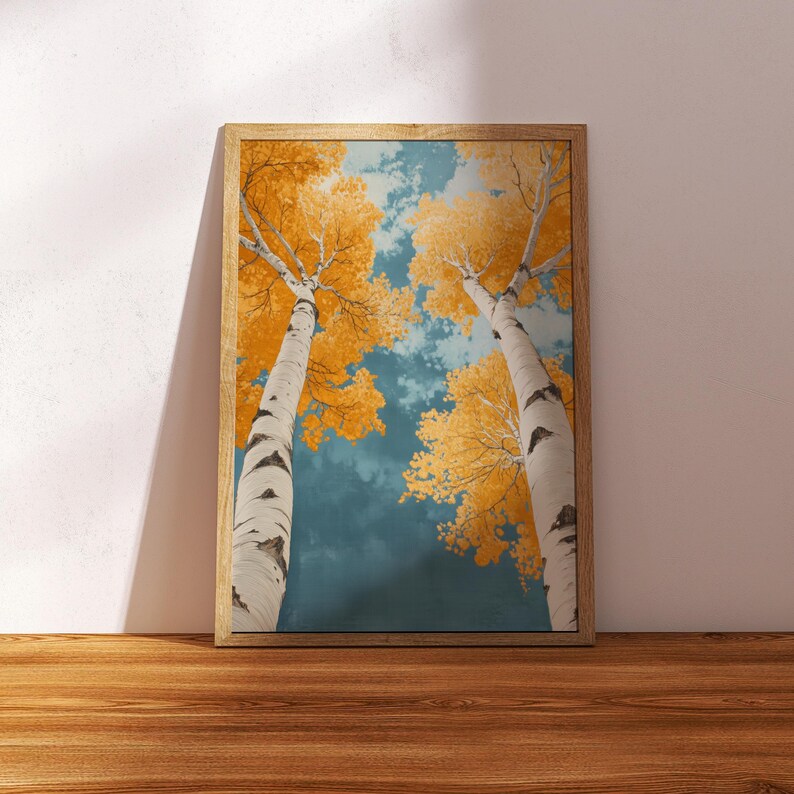 May include: A framed print of two birch trees with yellow leaves against a blue sky. The trees are viewed from below, looking up towards the sky.