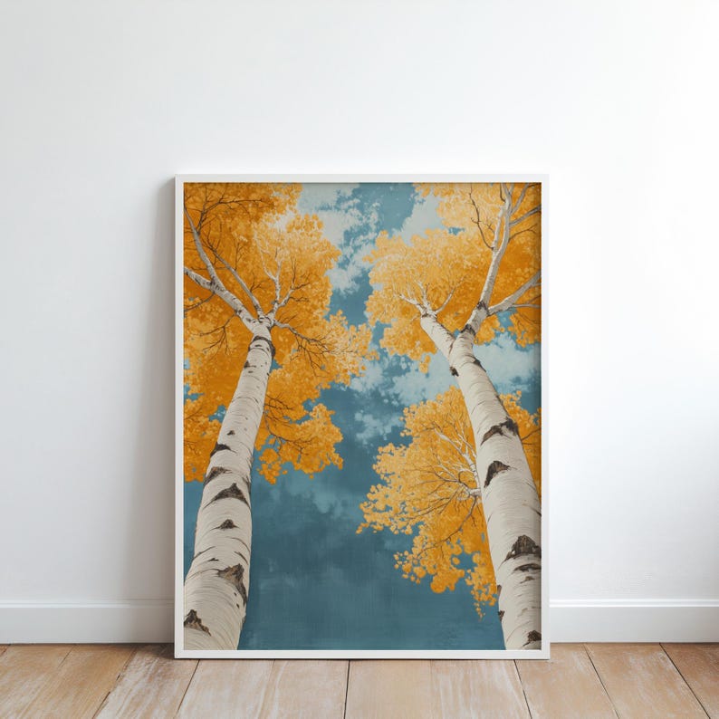 May include: Two tall birch trees with white bark and yellow leaves reach up towards a blue sky with white clouds. The trees are viewed from below, looking up at the sky.