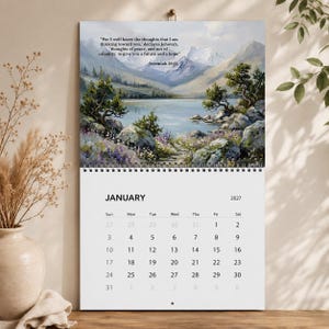 May include: A wall calendar for January 2027 featuring a landscape painting of a mountain lake with rocky shores and trees. The text reads: For I well know the thoughts that I am thinking toward you, declares Jehovah, thoughts of peace, and not of calamity, to give you a future and a hope, Jeremiah 29:11.