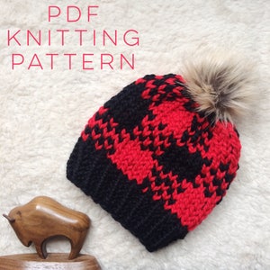 May include: PDF knitting pattern for a black and red plaid beanie with a faux fur pom pom.