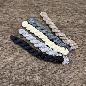 May include: Six skeins of embroidery floss in various shades of gray, black, and white.