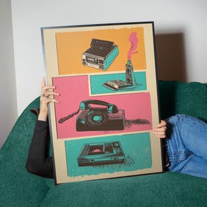 May include: A vintage-style poster with a comic book design featuring four retro electronics: a blue cassette player, a black rotary phone, a silver and black walkie-talkie, and a black and silver VCR.