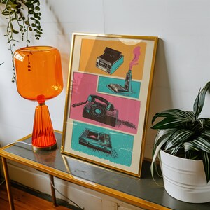 May include: A framed print with a retro design featuring a vintage phone, a cassette player, a camera, and a rotary phone. The print is on a light blue background with pink and yellow accents.