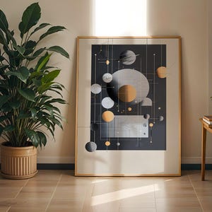 以下が含まれることがあります： 暗い背景にグレー、シルバー、ゴールドの幾何学模様が描かれた抽象的なプリントが額装されています。プリントには円、線、正方形が連なり、モダンでミニマルなデザインになっています。