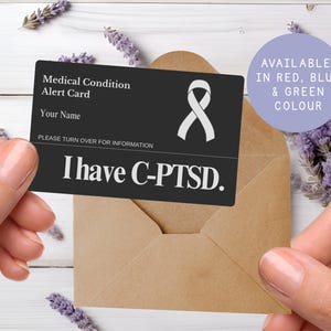 May include: A black medical alert card with the text "Medical Condition Alert Card" and "I have C-PTSD." A white ribbon symbol is on the card. The card is held in front of a brown envelope. Available in red, blue, and green.