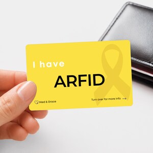 May include: A rectangular yellow card with rounded corners featuring the white text I have and the bold black text ARFID. A yellow awareness ribbon is printed on the right side. The bottom left shows the Med & Grace logo and text.