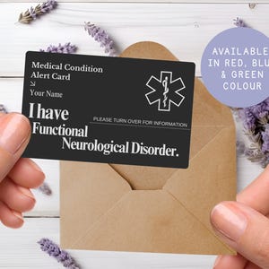 May include: A black medical alert card with white text and a medical symbol is held in front of a brown envelope. The card reads "I have Functional Neurological Disorder." A purple circle states "Available in Red, Blue & Green Colour."