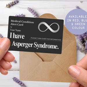 May include: A black medical alert card with the text "I have Asperger Syndrome" in white. The card also includes the text "Medical Condition Alert Card" and "Your Name". The card is held in front of a brown envelope and lavender sprigs.