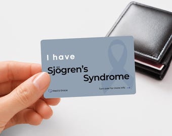 Puede incluir: Una tarjeta médica rectangular azul con un lazo de concienciación azul claro y el texto I have Sjögren's Syndrome, el logotipo de Med & Grace y una flecha hacia la derecha con el texto Turn over for more info.