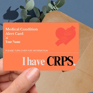 May include: A bright orange medical alert card with a heart graphic and the text "I have CRPS." The card has a space for the person's name and instructions to turn it over for more information.