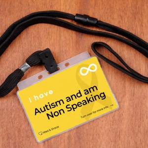 May include: A yellow rectangular identification card attached to a black fabric lanyard. The card features a white infinity symbol, a yellow ribbon graphic, and the black text: I have Autism and am Non Speaking. Turn over for more info.