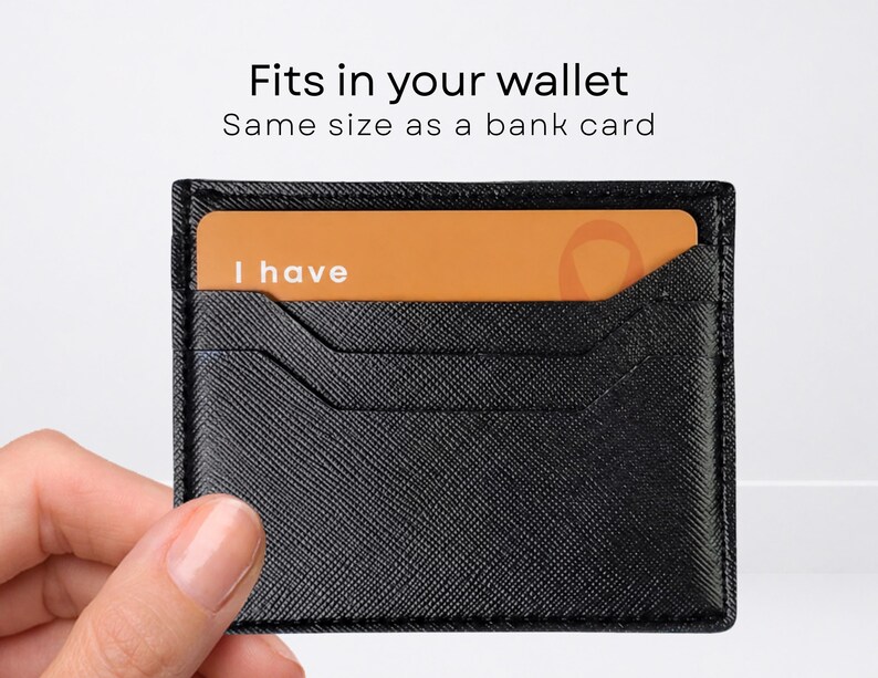 May include: A black textured card holder with a rectangular orange card inserted. The card features the white text "I have" on the left side. Above the card holder, the text reads "Fits in your wallet" and "Same size as a bank card."