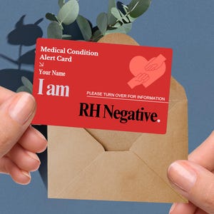 May include: A red medical alert card with the text "Medical Condition Alert Card" and "I am". The card also features a heart with hands graphic and the text "RH Negative."