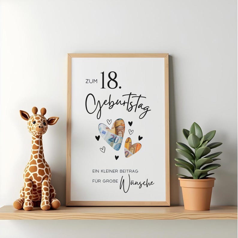 May include: A framed white poster with black text reading Zum 18. Geburtstag and Ein kleiner Beitrag f&uuml;r gro&szlig;e W&uuml;nsche. The design features two heart-shaped cutouts filled with Euro banknotes, surrounded by small black heart illustrations.