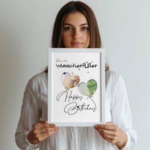 K&ouml;nnte beinhalten: Ein wei&szlig; gerahmter Druck mit dem Text "kleiner Wunscherf&uuml;ller" und "Happy Birthday" in schwarzer Schrift. Es sind zwei herzf&ouml;rmige Luftballons abgebildet, einer mit einem 50-Euro-Schein-Muster und der andere mit einem 100-Euro-Schein-Muster gef&uuml;llt.