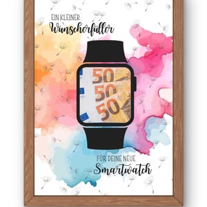 May include: A framed print with a watercolor background in shades of orange, pink, blue, and white. The image features a black smartwatch with a screen displaying three 50 Euro banknotes. Text in German reads "Ein kleiner Wunscherfüller für deine neue Smartwatch."
