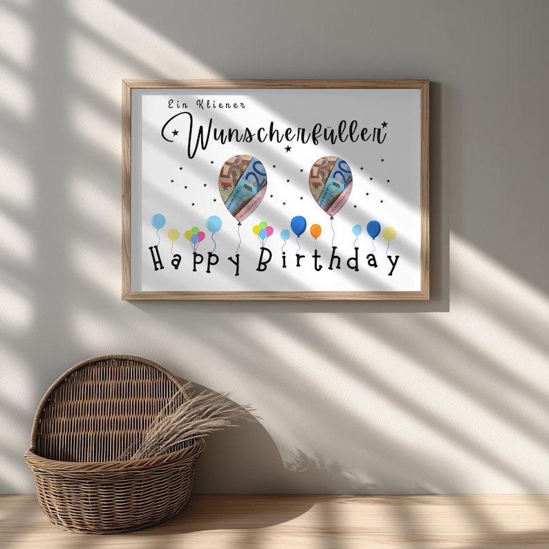 May include: A framed print with a wooden frame, featuring the words "Ein Kleiner Wunscherfuller" and "Happy Birthday". The artwork includes two balloon illustrations with money inside and colorful balloons at the bottom.