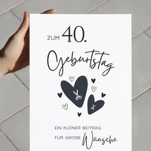 May include: A white rectangular greeting card with black text that reads ZUM 40. GEBURTSTAG, EIN KLEINER BEITRAG F&Uuml;R GROBE W&uuml;nsche. The design features two large dark hearts, several smaller hearts, and two small scissor icons centered on the card.
