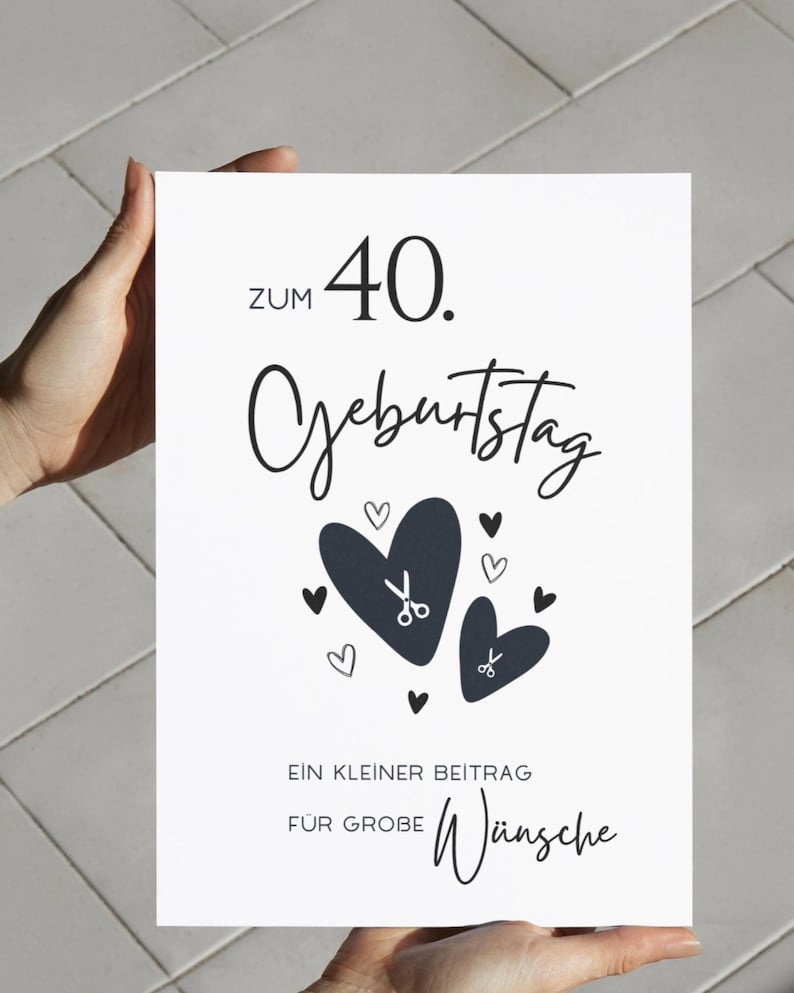 May include: A white rectangular greeting card with black text that reads ZUM 40. GEBURTSTAG, EIN KLEINER BEITRAG F&Uuml;R GROBE W&uuml;nsche. The design features two large dark hearts, several smaller hearts, and two small scissor icons centered on the card.