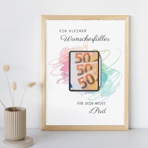 May include: A framed print featuring a light wood frame and white background. The text reads EIN KLEINER Wunscherf&uuml;ller F&Uuml;R DEIN NEUES iPad. In the center, a tablet illustration displays three fifty-euro banknotes with a stylus attached to the side.