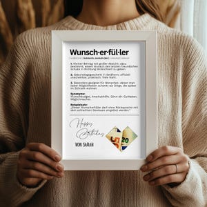 May include: A framed print with the German word "Wunsch-er-f&uuml;l-ler" and its definition. The print includes the text "Happy Birthday" and the name "VON SARAH" below a collage of money.