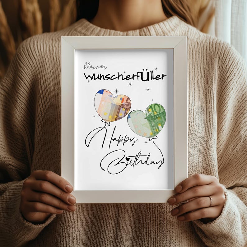 K&ouml;nnte beinhalten: Ein wei&szlig;er rechteckiger Rahmen mit einem Druck, der den Text "kleiner Wunscherf&uuml;ller" und "Happy Birthday" in schwarzer Schrift zeigt. Das Design enth&auml;lt zwei herzf&ouml;rmige Luftballons, die mit F&uuml;nf- und Hundert-Euro-Scheinen gef&uuml;llt sind.